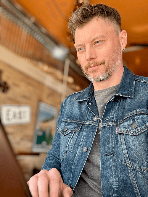 Photo of Jesse Earley sitting in Toads coffee shop working remotely.